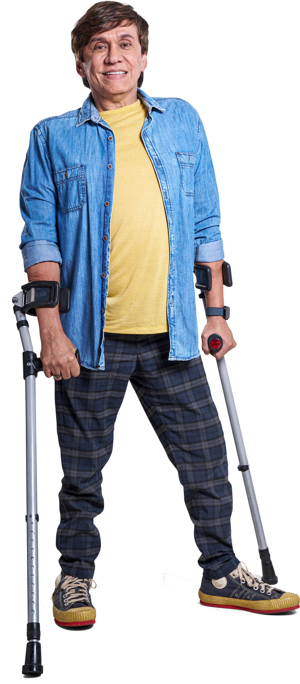 Homem sorrindo de pé. Vestindo jaqueta azul e calça quadriculada. Segurando moletas.